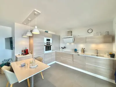 a kitchen with a table and a dining room at Appartement 26 les terrasses de l'isolella Porticcio in Porticcio