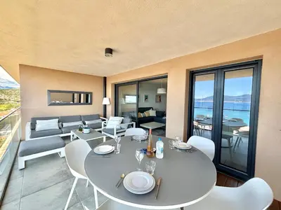 a living room with a table and chairs and a couch at Appartement 26 les terrasses de l'isolella Porticcio in Porticcio