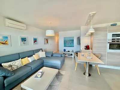 a living room with a blue couch and a table at Appartement 26 les terrasses de l'isolella Porticcio in Porticcio