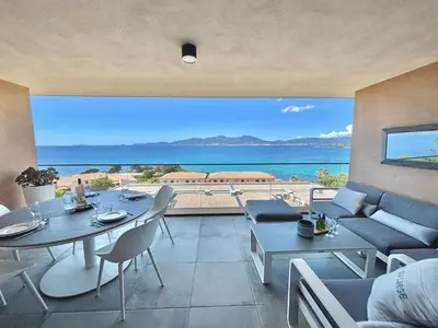 a living room with a view of the ocean at Appartement 26 les terrasses de l'isolella Porticcio in Porticcio