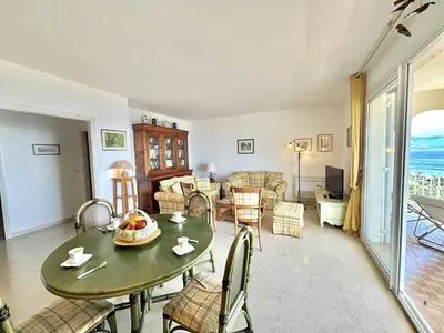 a living room with a table and chairs at Appartement Le Panoria sanguinaires Ajaccio in Ajaccio