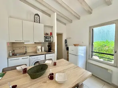 a kitchen with white cabinets and a wooden table at Appartement 317 Paesollu Porticcio in Porticcio