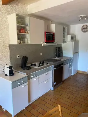 a kitchen with white cabinets and a white refrigerator at closerie in Grosseto-Prugna