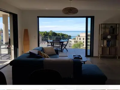 a living room with a couch and a view of the ocean at Porticcio - appartement T3 in Albitreccia