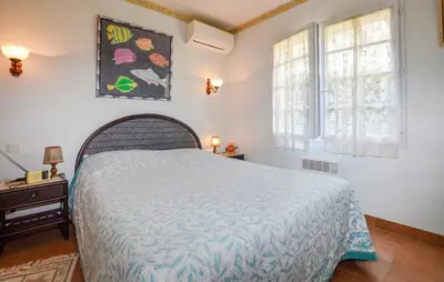 a bedroom with a bed with a blue bedspread at Maison Vue Mer Panoramique in Appietto