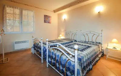 a bedroom with two beds with blue and white sheets at Maison Vue Mer Panoramique in Appietto