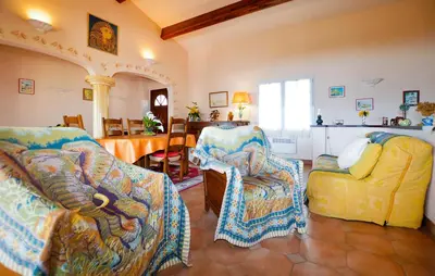 a living room with two chairs and a couch at Maison Vue Mer Panoramique in Appietto