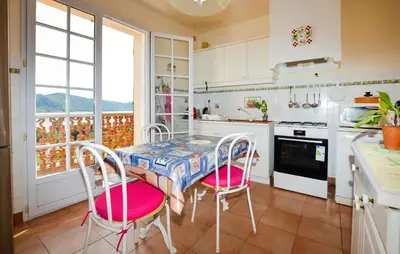a kitchen with a table and chairs and a window at Maison Vue Mer Panoramique in Appietto