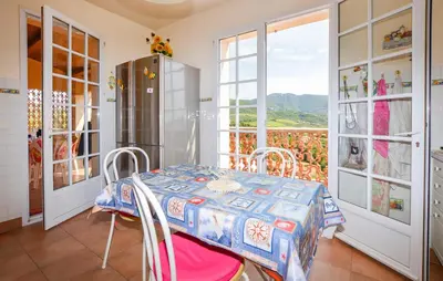 a dining room with a table and a window at Maison Vue Mer Panoramique in Appietto