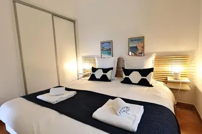 a bedroom with a large white bed with towels on it at Sous le Pin - Villa paisible face aux îles Lavezzi in Bonifacio