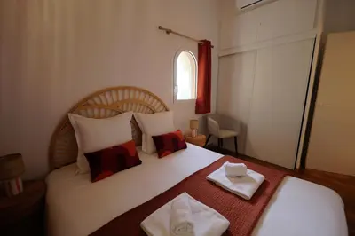 a bedroom with a bed with two towels on it at Sous le Pin - Villa paisible face aux îles Lavezzi in Bonifacio