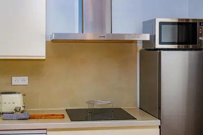 a kitchen with a microwave and a refrigerator at U Vermentinu in Aghione