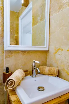 a bathroom sink with a mirror and a towel at U Vermentinu in Aghione