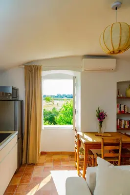 a kitchen and dining room with a table and a window at U Vermentinu in Aghione