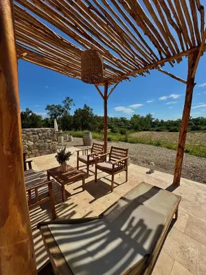 a group of benches sitting under a wooden umbrella at Suite du Domaine Marquiliani in Fautea