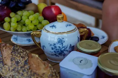 a table with a tea pot and a bowl of fruit at Suite du Domaine Marquiliani in Fautea