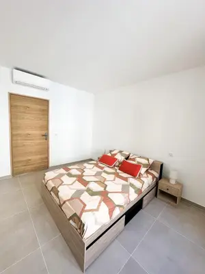 a bedroom with a large bed with red pillows at Charmant T3 au coeur d'Ajaccio in Ajaccio