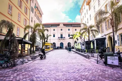 a cobblestone street with palm trees and a building at Charmant T3 au coeur d'Ajaccio in Ajaccio