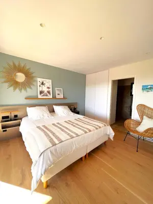 a bedroom with a large bed and a chair at Casa Sarra Di Pinarello in Pinarellu