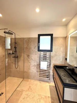 a bathroom with a shower with a window and a sink at Casa Sarra Di Pinarello in Pinarellu