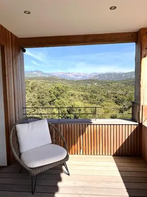 a wicker chair sitting on a balcony with a view at Casa Sarra Di Pinarello in Pinarellu