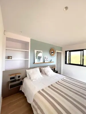 a bedroom with a large bed and a window at Casa Sarra Di Pinarello in Pinarellu