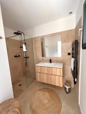 a bathroom with a sink and a shower with a mirror at Casa Sarra Di Pinarello in Pinarellu