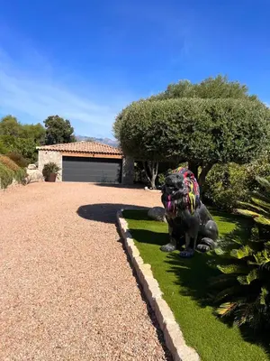 a statue of a dog sitting in the grass at Casa Sarra Di Pinarello in Pinarellu