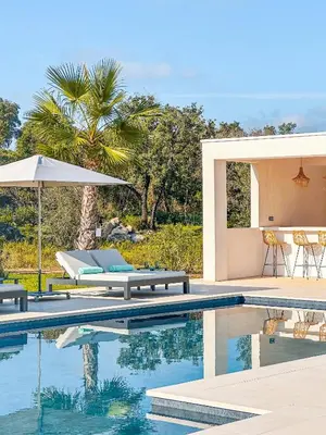 a pool with two lounge chairs and an umbrella at Villa Alimea San Ciprianu in Cirendinu