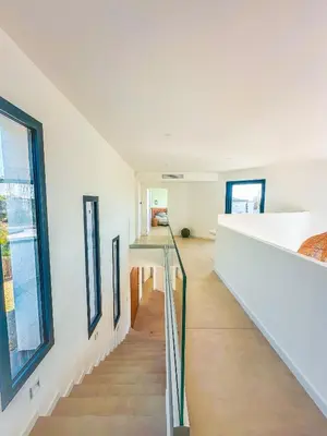 a staircase in a house with white walls and windows at Villa Alimea San Ciprianu in Cirendinu
