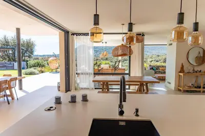 an open kitchen with a table and a dining room at Villa Alba Di Pinarello in Pinarellu