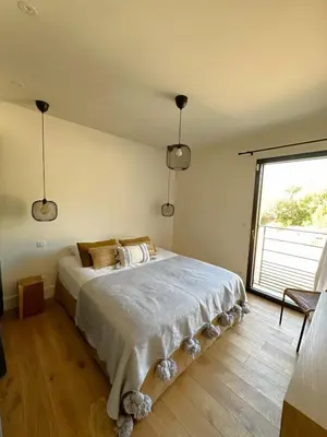 a bedroom with a large bed with a large window at Villa Alba Di Pinarello in Pinarellu