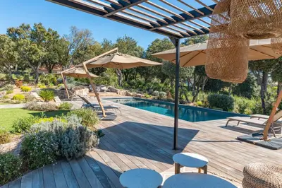 a patio with a swimming pool and umbrellas at Villa Alba Di Pinarello in Pinarellu