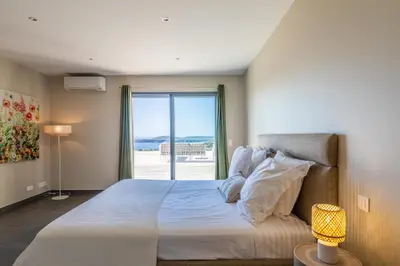 a bedroom with a large bed with a window at Villa Ghjiseppina Di Pinarello in Pinarellu