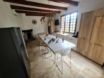 a kitchen with a white table and chairs in a room at Maison - chambres d'hotes in Prunelli-di-Fiumorbo
