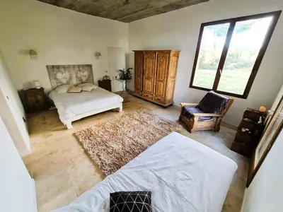 a bedroom with a bed and a chair at Maison - chambres d'hotes in Prunelli-di-Fiumorbo