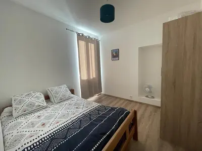 a white bedroom with a bed with pillows on it at CASA Marie-PAULINE in Sampolo