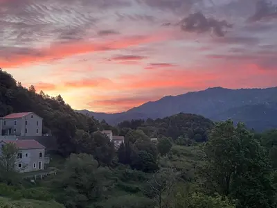 a sunset in the mountains with houses and trees at CASA Marie-PAULINE in Sampolo