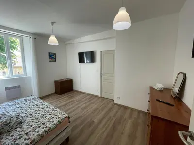 a bedroom with a bed and a dresser and a window at CASA Marie-PAULINE in Sampolo