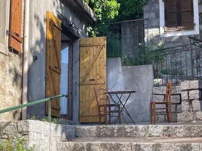 two chairs and a table in front of a door at CASA Marie-PAULINE in Sampolo