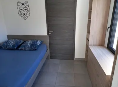 a small bedroom with a blue bed in a room at porticcio in Porticcio