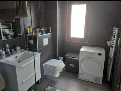 a bathroom with a toilet and a sink and a window at porticcio in Porticcio