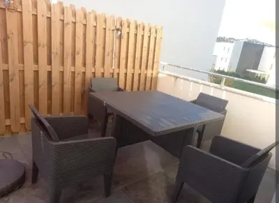 a wooden table and chairs on a balcony at porticcio in Porticcio