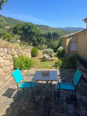 a table and two chairs on a patio at T2 dans villa avec piscine in Porto-Vecchio
