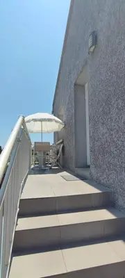 a patio with a table and an umbrella at Haut de villa in Cervione