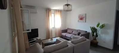a living room with a couch and a tv at Haut de villa in Cervione