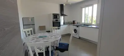 a kitchen with a table and a kitchen with a table and chairs at Haut de villa in Cervione
