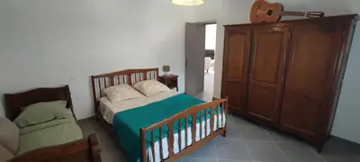 a bedroom with a bed and a wooden cabinet at Haut de villa in Cervione