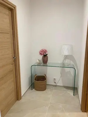 a glass table with a lamp and flowers on it at Charming stone villa with pool in Figari