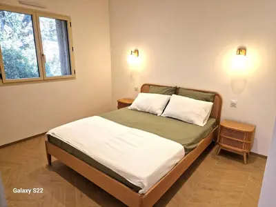 a bedroom with a bed with two pillows and a window at Charming stone villa with pool in Figari